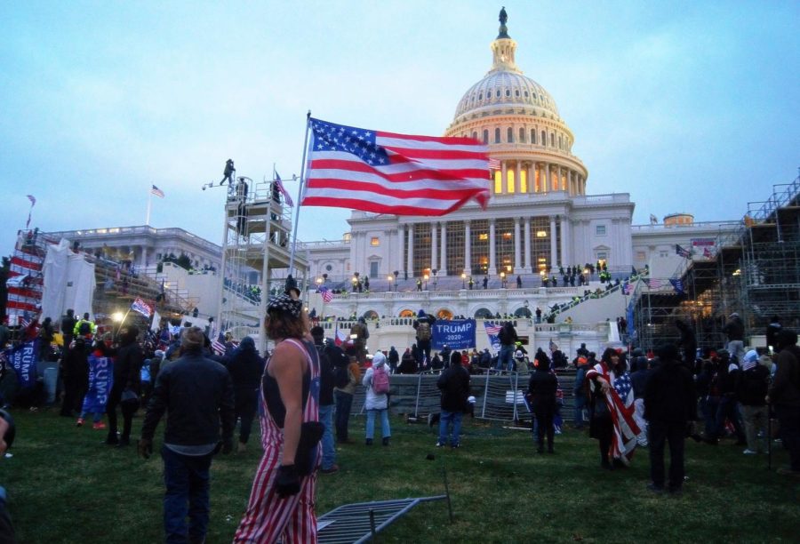 Protester+proudly+displays+the+American+flag+as+the+Capitol+is+infiltrated.+