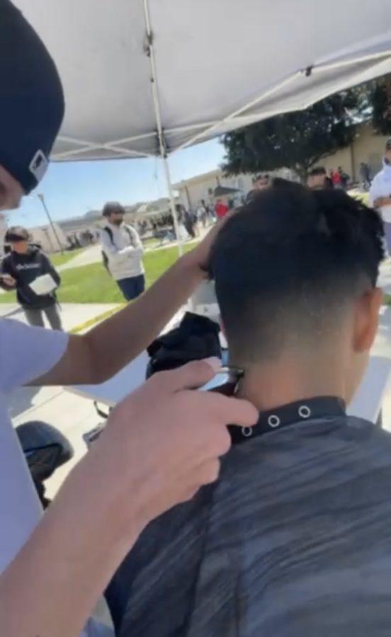 Ivan Rojas cutting students hair in the AGHS quad.