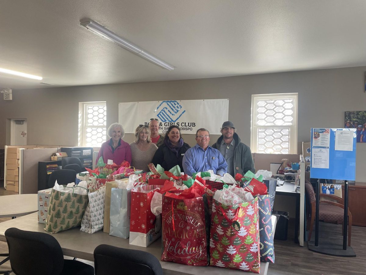Grover Beach Rotary Club board members and Boys and Girls Club coordinator stand proudly by the 40 plus coats the club donated.