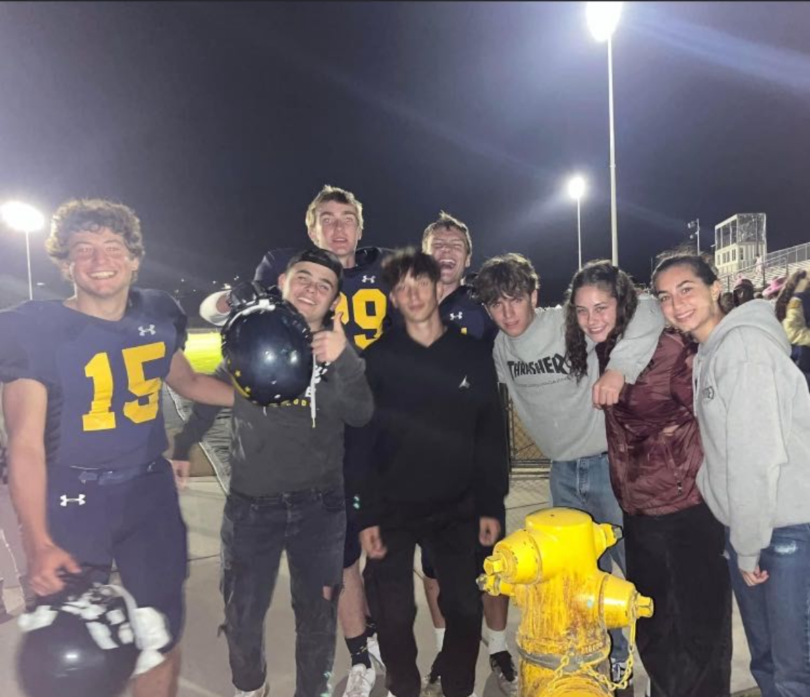Most of the foreign exchange students coming together and celebrating after a won football game