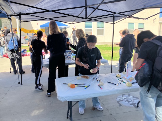 Students paint pumpkins during the lunchtime activity in honor of fall.