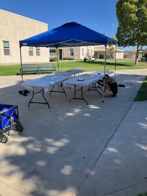 A student setting up tables before the lunchtime activity.