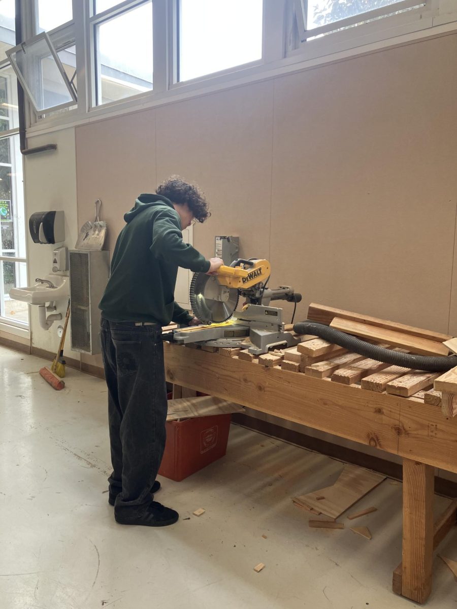 Monday, 2:19 PM: Woodworking student Deker Blackburn saws away. 