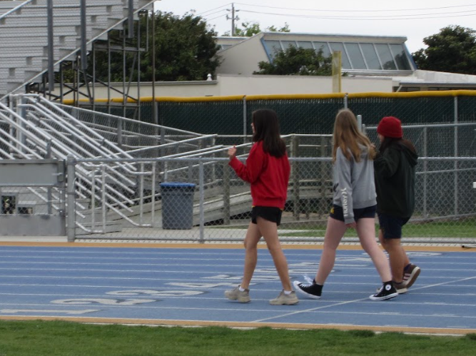 Monday 2:36 p.m. - Students in the fifth-period P.E. class walk their laps around the track, talking and laughing with each other. 