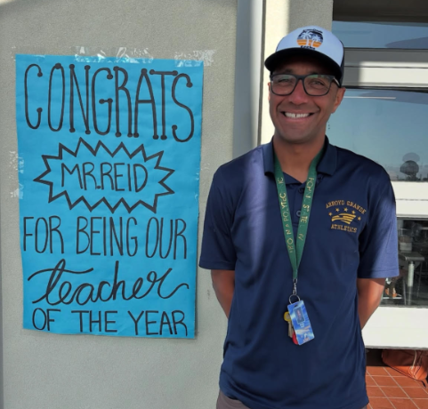 Phillip Reid proudly standing by his Teacher of the Year poster.
