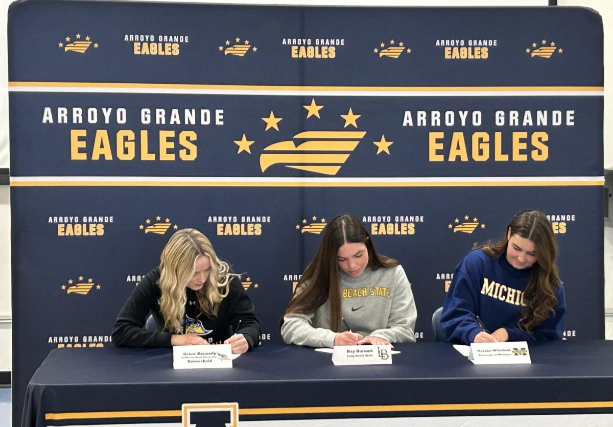Surrounded by peers, coaches and family Grace Kennedy, Bay Burnett and Natalie Whitfield make their commitments .