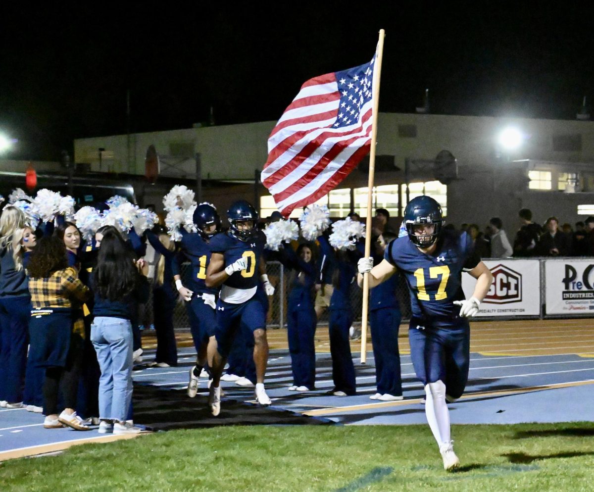 Tayman carries the American flag his last high school game.