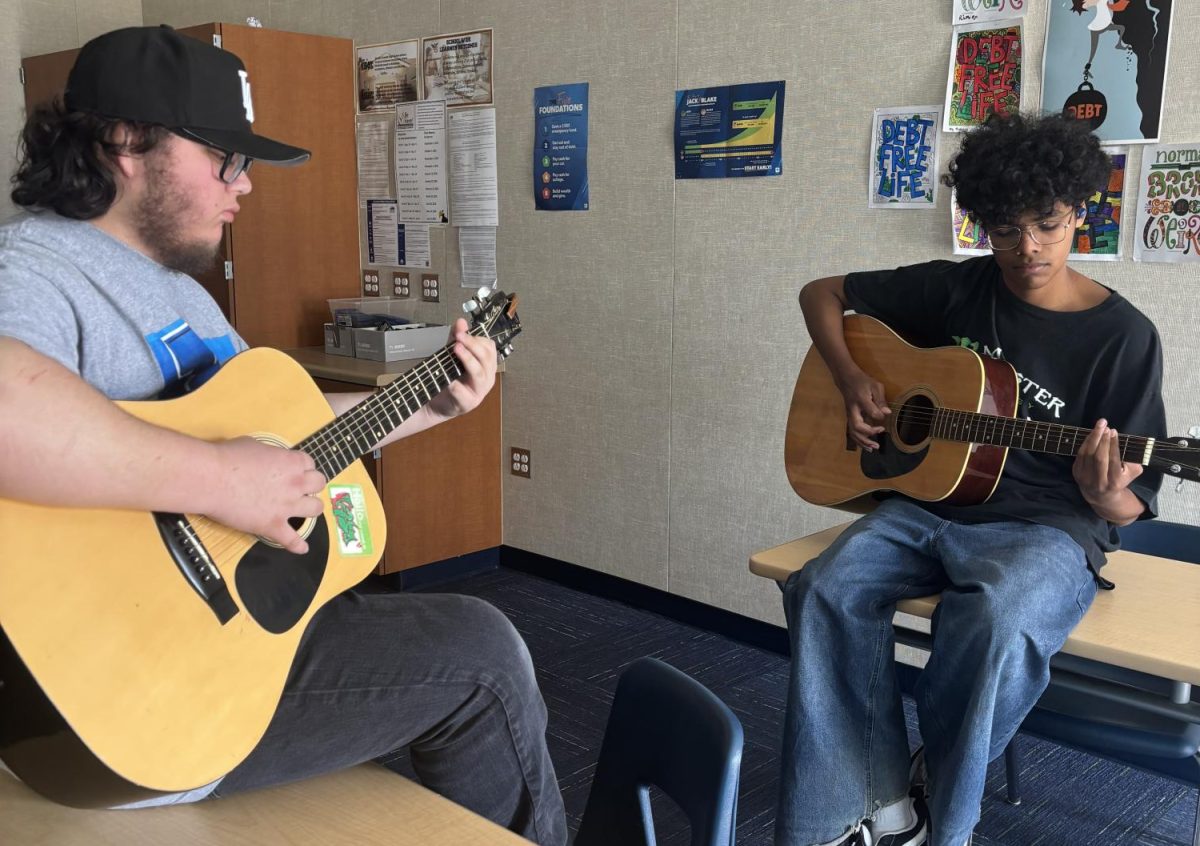 Club President Jacob Uc and Bryan Gamboa practice playing their guitars.