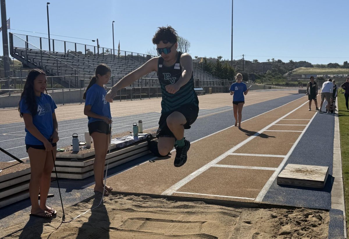 Athlete Carlos, from Pioneer Valley, launches himself into the sandpit during the long jump.