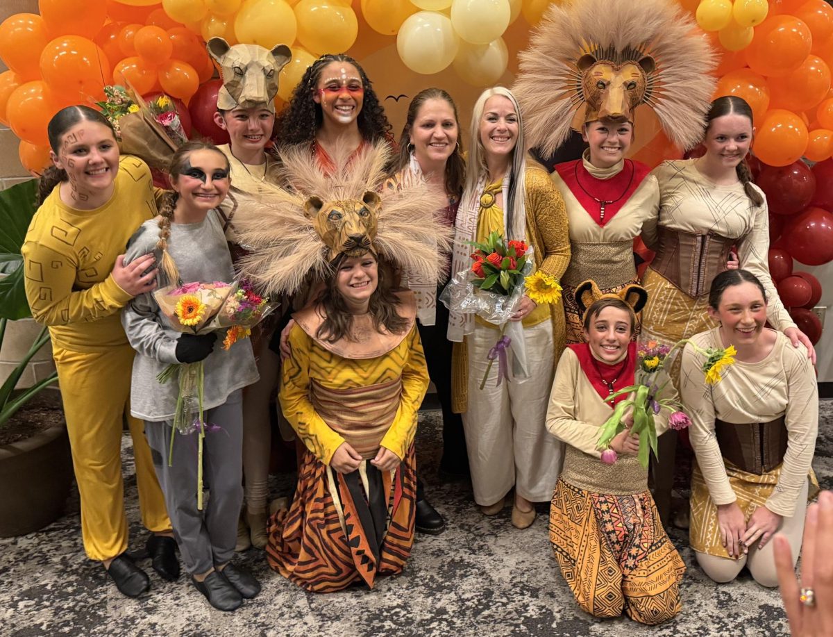 Geyer (center right) surrounded by cast with costume designer Jamie Douglas (center left)
